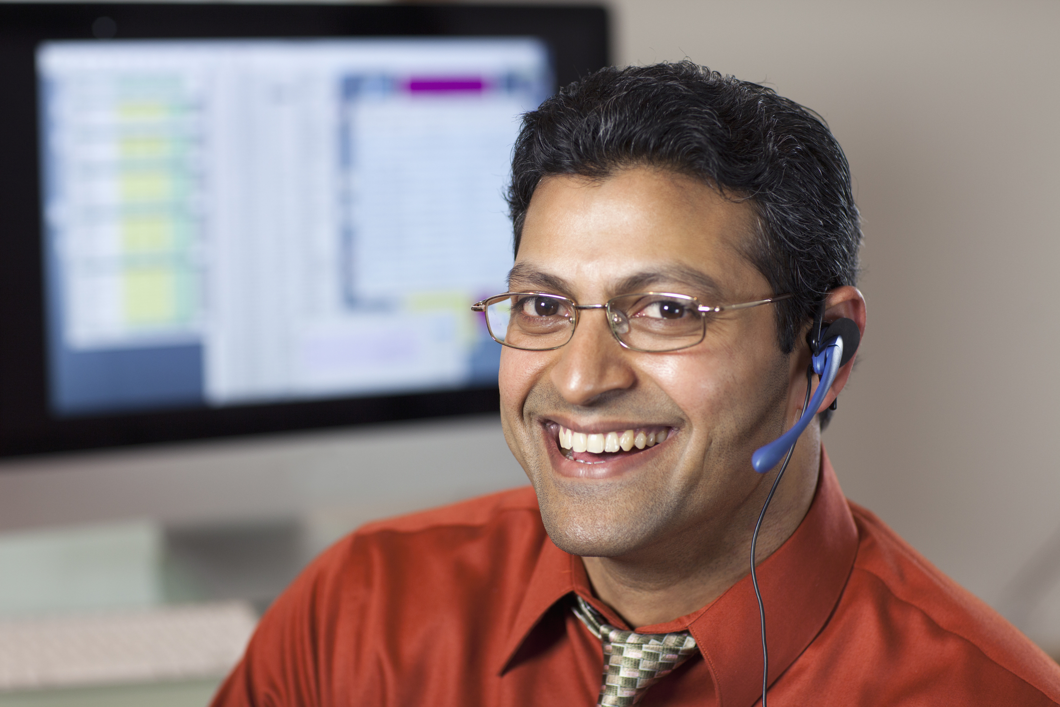 Smiling support agent taking a call on a headset